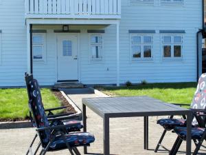 duas cadeiras e uma mesa em frente a uma casa em Apartment Galanten - FJH609 by Interhome em Lunde