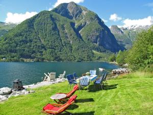 un grupo de sillas y una mesa con vistas al lago en Chalet Villa Esefjord - FJS003 by Interhome en Balestrand