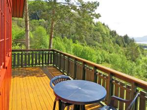 un balcón de madera con mesa y sillas. en Holiday Home Fjordperlen - FJS145 by Interhome, en Sørbø
