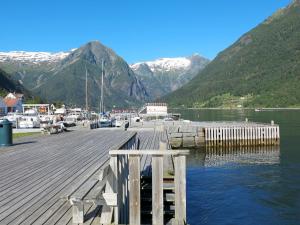 ein Dock auf einem See mit Bergen im Hintergrund in der Unterkunft Holiday Home Tussviki - FJS020 by Interhome in Balestrand