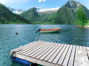 a boat is docked at a dock on a lake at Holiday Home Pærehagen - FJS297 by Interhome in Balestrand
