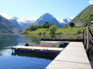 two boats docked at a dock on a lake with mountains at Holiday Home Tantestova - FJS296 by Interhome in Balestrand