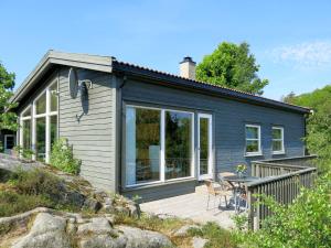una casa pequeña con terraza y mesa en Chalet Smibakken - SOW016 by Interhome, en Farsund