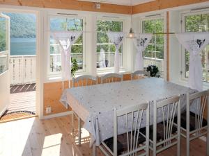 a dining room with a table and windows at Chalet Kvitveis - FJS392 by Interhome in Gudvangen