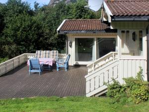a deck with a table and chairs on a house at Holiday Home Åptafjorden - SOW684 by Interhome in Farsund