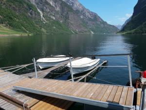 two boats are docked at a dock on a lake at Chalet Kvitveis - FJS392 by Interhome in Gudvangen