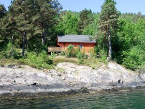 a small red cabin on the side of a river at Holiday Home Maria - FJS114 by Interhome in Balestrand