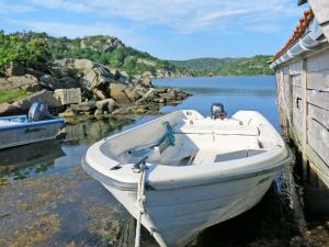 a white boat in the water next to a building at Holiday Home Klippen - SOW615 by Interhome in Farsund