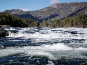 Un río con rápidos en él con montañas en el fondo en Chalet Flatebygd - SOO355 by Interhome, en Evje