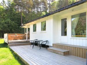 靈達爾的住宿－Holiday Home Espeøya - SOW045 by Interhome，房屋一侧的木甲板上配有桌子