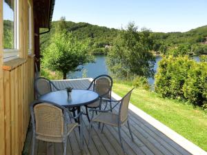 una mesa y sillas en una terraza con vistas al lago en Holiday Home Espeøya - SOW045 by Interhome, en Lyngdal