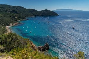 a view of a beach with boats in the water at Boutique Hotel Torre Di Cala Piccola in Porto Santo Stefano