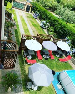 B&B Villa dei Fiori في سانت أوفيميا لاميتسيا: اطلالة علوية على طاولات وكراسي مع مظلات