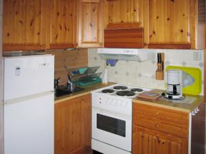 y cocina con fogones blancos y nevera. en Chalet Slåttenes - FJH415 by Interhome, en Naustflot