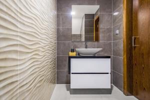 ein Bad mit einem Waschbecken und einem Spiegel in der Unterkunft Terrazzos do Prado - Vista Ria de Aveiro in Costa Nova