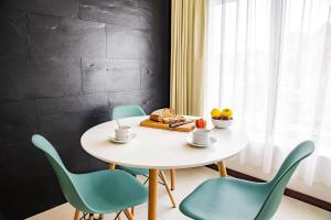 - une table et des chaises blanches dans la chambre dans l'établissement Terrazzos do Prado - Vista Ria de Aveiro, à Costa Nova