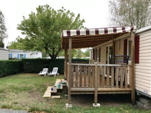 un porche con cenador y 2 sillas en Mobil-home Camping au MATHES, en Les Mathes