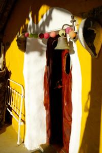 una campana colgando en un lado de una casa en The Hobbit House - Montes da Ronha, en Odemira