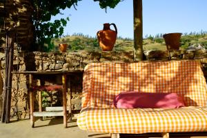 a couch sitting in front of a stone wall at The Hobbit House - Montes da Ronha in Odemira