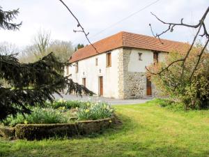una antigua casa de piedra con un jardín delante de ella en Holiday Home La Voisinière no- 3 - SVY406 by Interhome, en Savigny