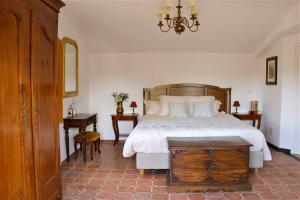 a bedroom with a large bed and a chandelier at La Vieille Ferme de Grasse in Grasse