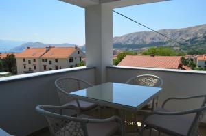 d'une table et de chaises sur un balcon avec vue sur les montagnes. dans l'établissement Apartments Sušec, à Baška