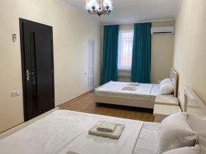 a bedroom with two beds and a chandelier at West House in Kobuleti