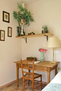 Habitación con escritorio con lámpara y silla. en La Vieille Ferme de Grasse, en Grasse