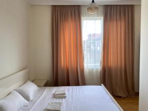 una camera da letto con un letto bianco e una finestra di West House a Kobuleti