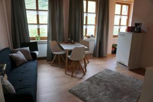 a living room with a couch and a table with chairs at Weingut Göbel-Schausten in Ernst