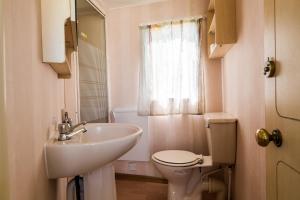 a white bathroom with a sink and a toilet at Rowyhills in Rowy