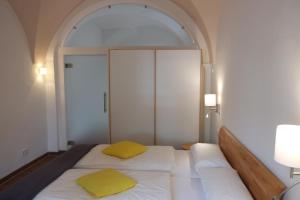 una camera con 2 letti con cuscini gialli di 60qm Wohnung Naabtal im historischen Pfarrhaus Pielenhofen a Pielenhofen