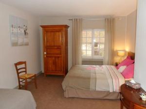 a bedroom with a bed and a chair and a window at Domaine de La Héllière in Lailly-en-Val