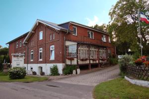a large brick building with a flag in front of it at Ostsee Pension Pohnsdorfer Mühle in Sierksdorf