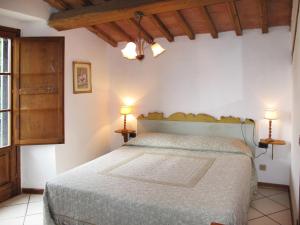 a bedroom with a bed and two lamps on tables at Holiday Home Chiesa by Interhome in Linari
