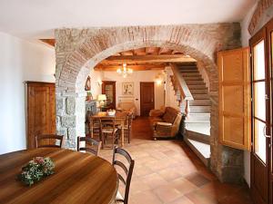 sala de estar con mesa y pared de piedra en Holiday Home Fienile by Interhome en Linari