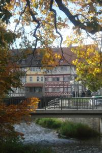 un puente sobre un río frente a un edificio en Altstadtapartment an der Krämerbrücke en Erfurt