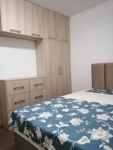 a bedroom with a bed with a blue blanket with white flowers at Vila Ena in Stanišiči