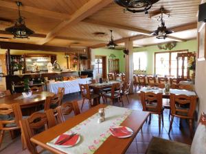 uma sala de jantar com mesas e cadeiras de madeira em Pension und Bauernhof Petzold em Greiz