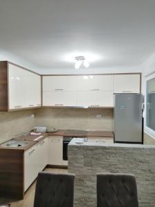 a kitchen with white cabinets and a refrigerator at Vila Ena in Stanišiči