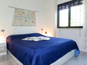 a bedroom with a blue bed with a blue blanket at Holiday Home La Sirenetta by Interhome in Castiglione della Pescaia