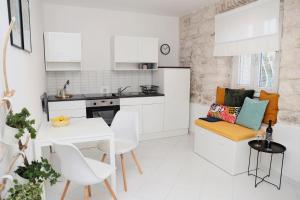 a kitchen with white cabinets and a table and chairs at Korcula perfect spot in Korčula