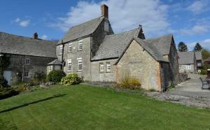 uma grande casa de tijolos com um quintal verde em The Bird In Hand Inn, Witney em Witney