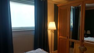a bedroom with a lamp next to a window at DerOstseegast in Heiligenhafen