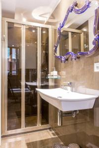 uma casa de banho com um lavatório branco e um espelho. em Residence Suite a Venezia em Veneza