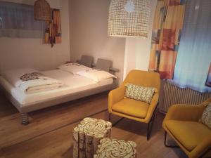 una piccola camera da letto con un letto e una sedia di Motel - Hôtel "Inter-Alp" à St-Maurice a Saint-Maurice