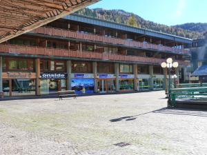 a large building with a bench in front of it at Bilocali Alberti - Rainalter in Madonna di Campiglio