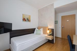 A bed or beds in a room at Wesenufer Hotel & Seminarkultur an der Donau