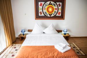 a bedroom with a large bed and a picture on the wall at Club Residence Apartments in Neptun