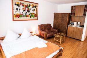 a bedroom with a bed and a chair in a room at Club Residence Apartments in Neptun